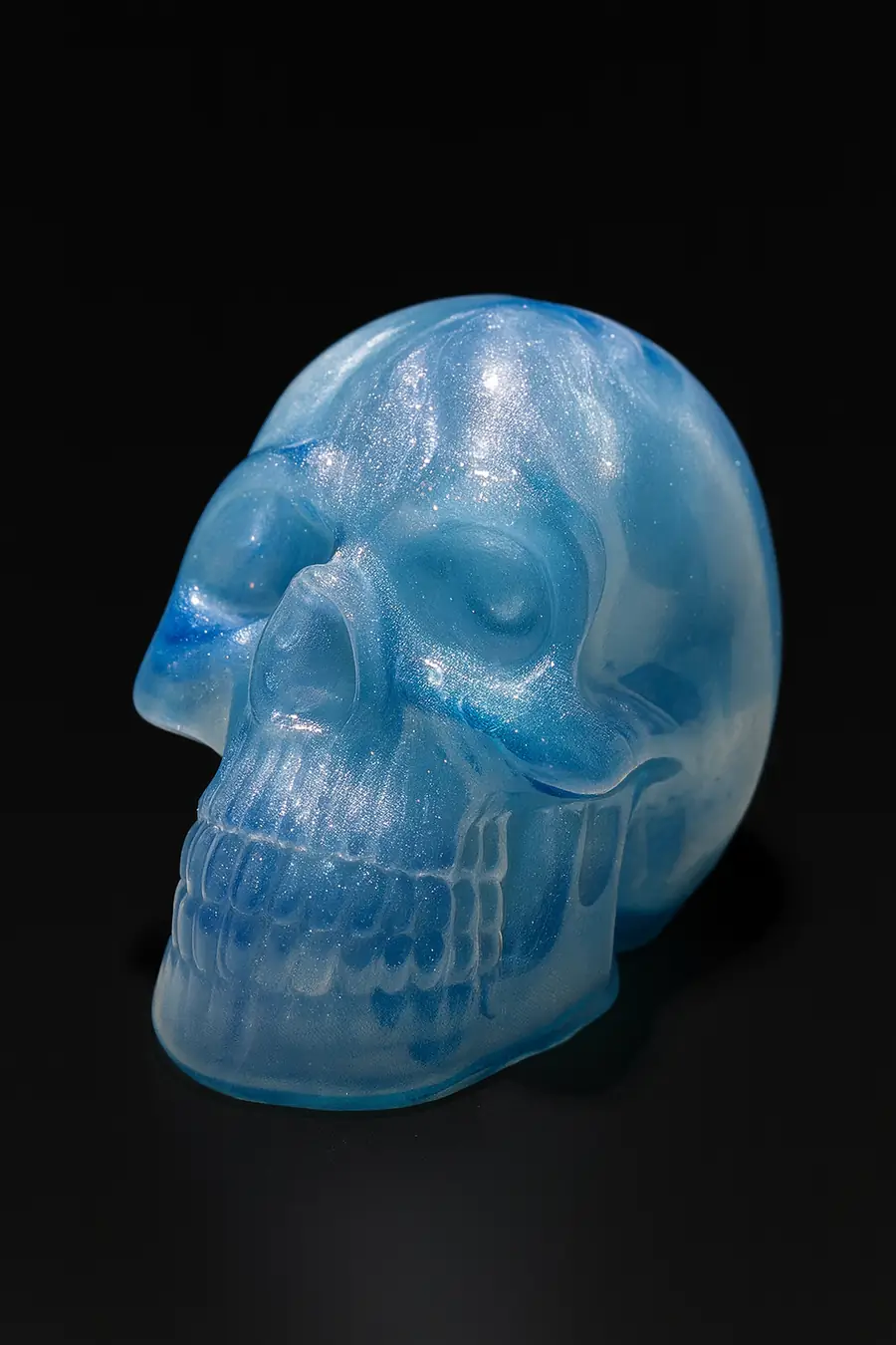 A resin skull sculpture in translucent ice blue is